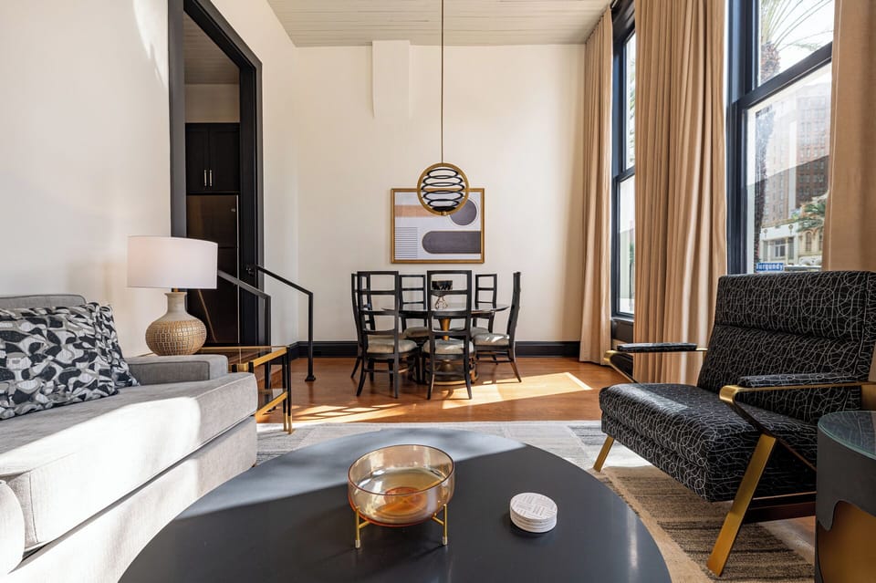 A bright, inviting dining and living area with floor-to-ceiling windows framing a stunning city view.