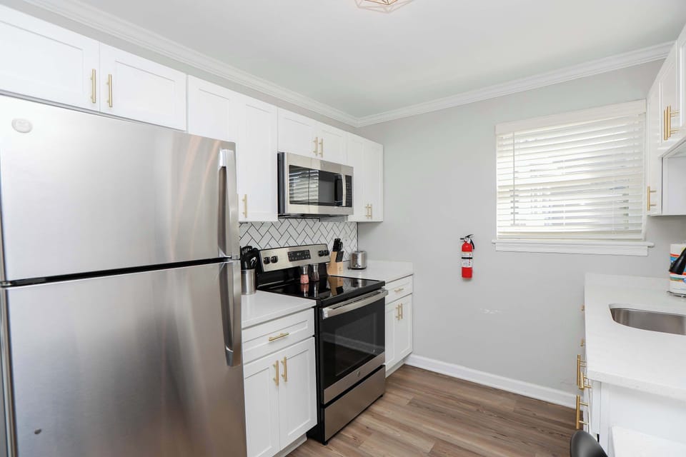 Full kitchen with cabinets for storage.