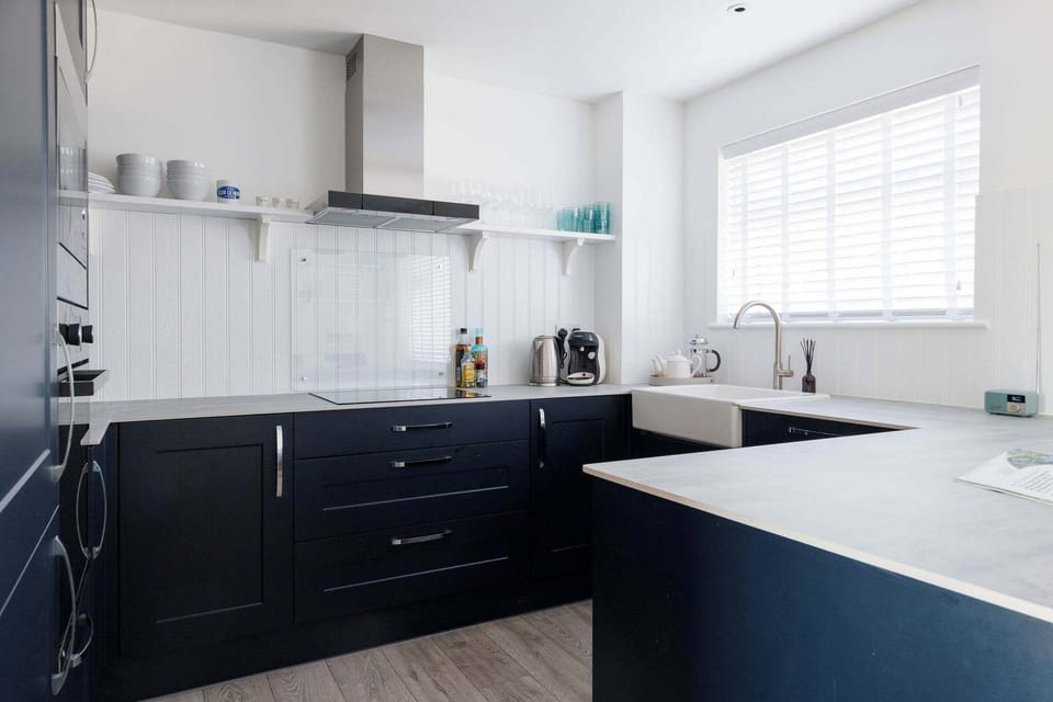Modern kitchen with sleek navy cabinets and full amenities