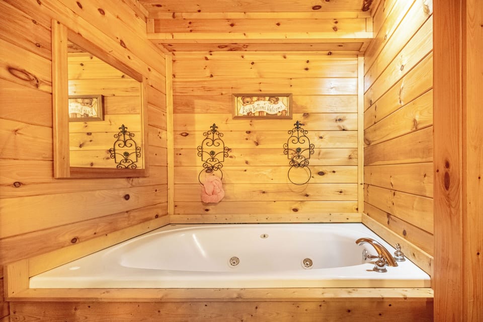 Indulge in a luxurious whirlpool tub surrounded by warm, inviting wood.