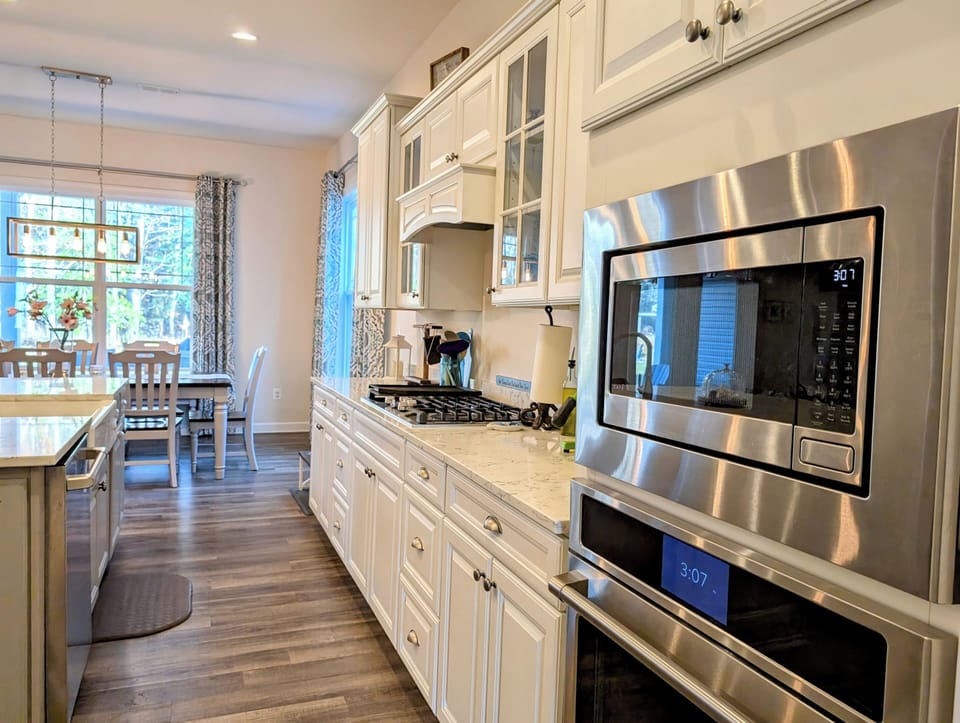 51 Beach Club Avenue - Kitchen Interior - Detailed view of the kitchen's workspace, highlighting the built-in microwave and oven, and its seamless flow into the bright dining area.