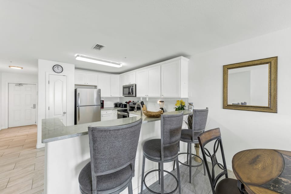 Your sleek kitchen island becomes the heart of your stay, with modern appliances and counter seating perfect for morning coffee or casual meals.