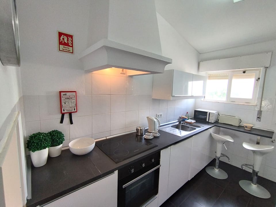 Well-equipped kitchen with breakfast bar has a laundry room at the end