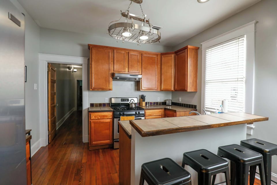 Kitchen featuring a full set of appliances, bar seating at the counter, and all the cookware, dishes, and utensils you could need.