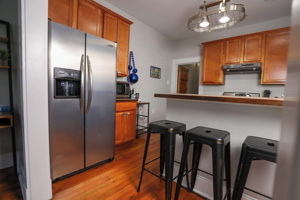 Kitchen featuring a full set of appliances, bar seating at the counter, and all the cookware, dishes, and utensils you could need.