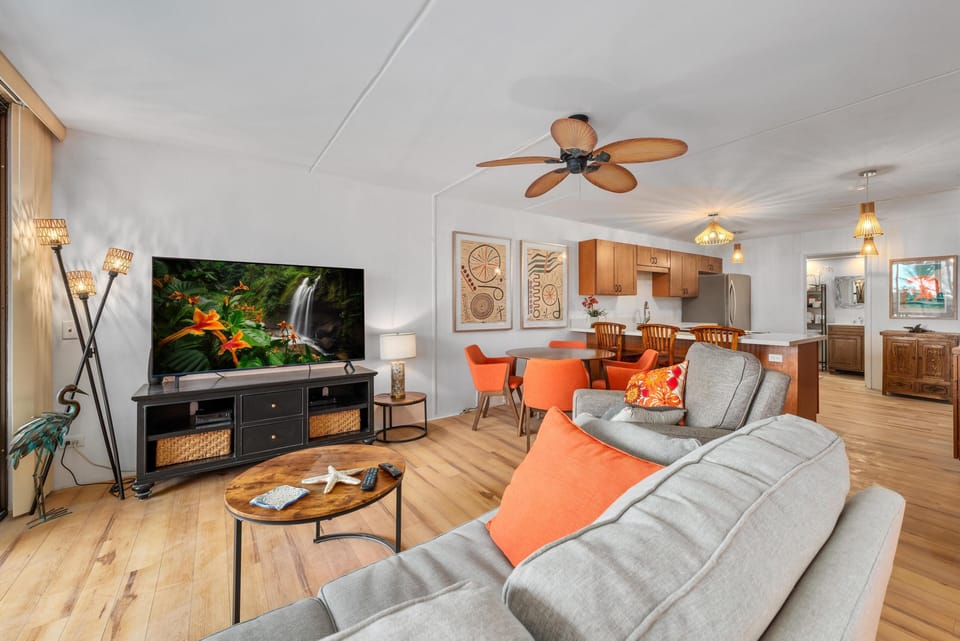 Comfortable living room with plush seating, a flat-screen TV & ceiling fan