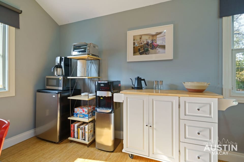 Your all-in-one kitchenette: a coffee maker, microwave, and mini-fridge for easy bites, plus a cabinet for extra storage and a rack stocked with books and games for your downtime