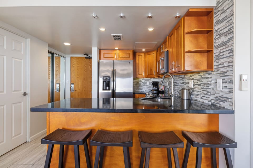 Gather at the sleek breakfast bar, where modern style meets comfort. Stainless appliances and custom backsplash create your perfect home-away-from-home cooking space.