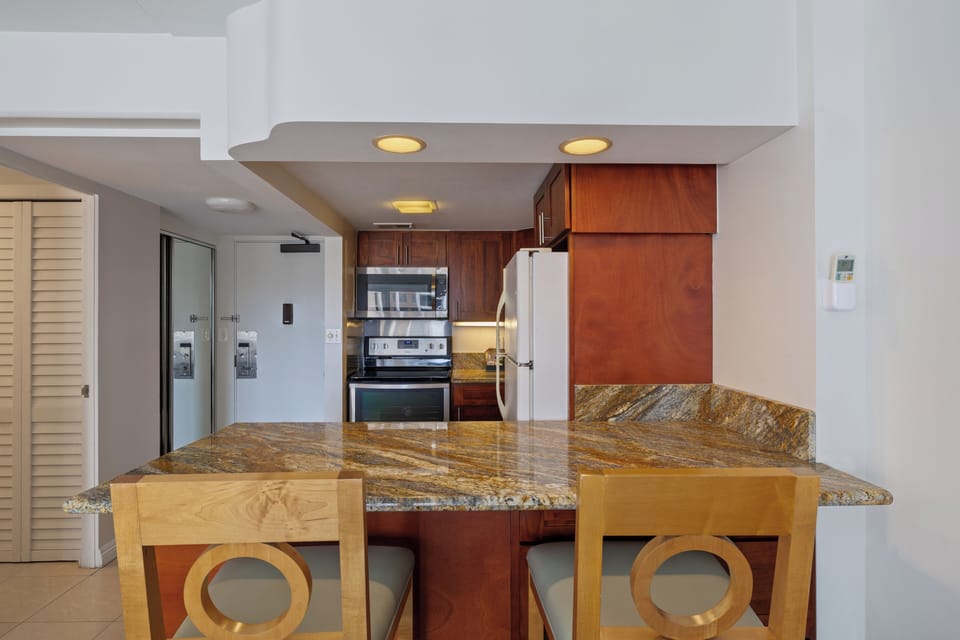 Gather around your granite-topped island where warm wood cabinetry and modern appliances invite you to prepare memorable meals together.