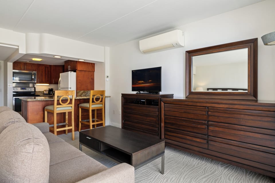 Unwind in your spacious living area featuring a plush sofa, flat-screen TV, and full kitchen with modern appliances—all yours to enjoy during your stay.