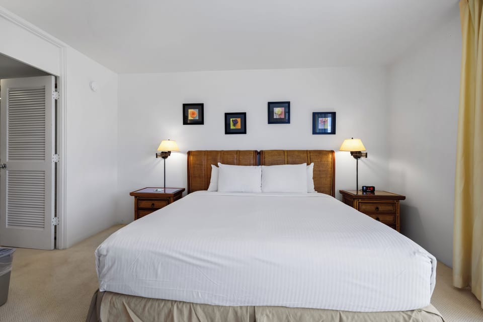 Sink into crisp white linens and unwind in your tranquil retreat with warm tropical touches and gentle bedside lighting.