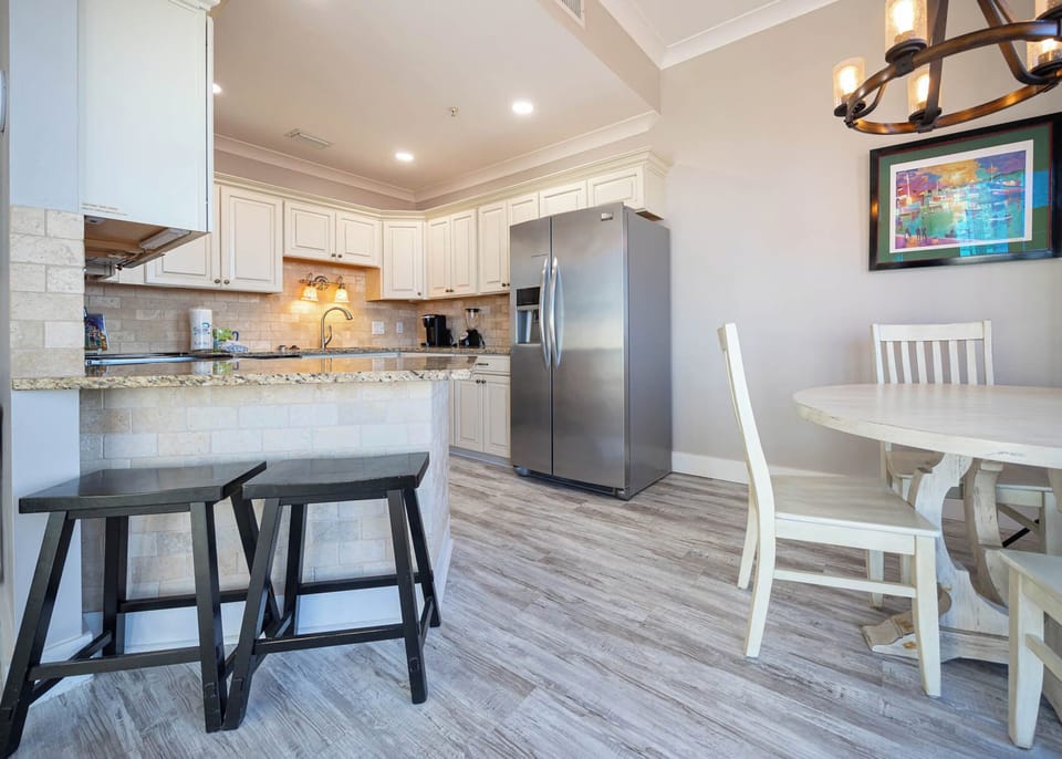 Gather around the round table in this inviting kitchen, featuring sleek appliances and warm lighting for a cozy atmosphere