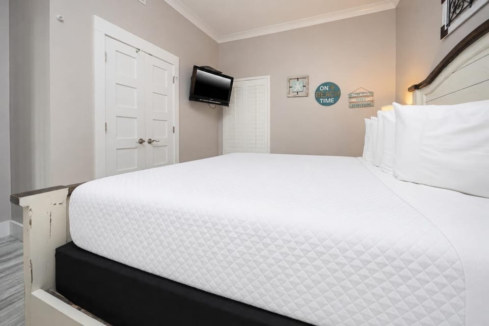 Inviting master bedroom featuring a plush king bed, decorative accents, and a wall-mounted TV for your entertainment