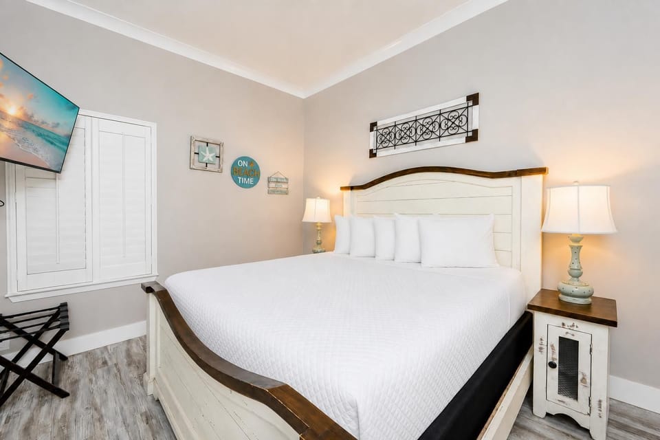 Rest comfortably in this inviting master bedroom featuring a king bed, soft lighting, and charming coastal decor