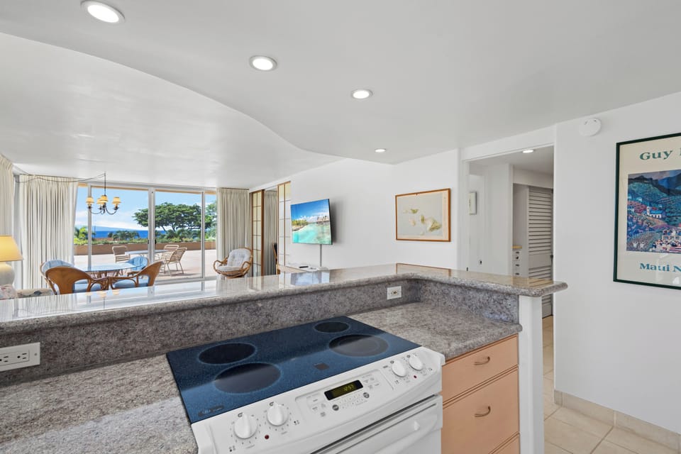 Bright open kitchen flows into the living area, where stunning ocean views greet you through expansive windows. Notice the ocean vista just beyond the balcony.