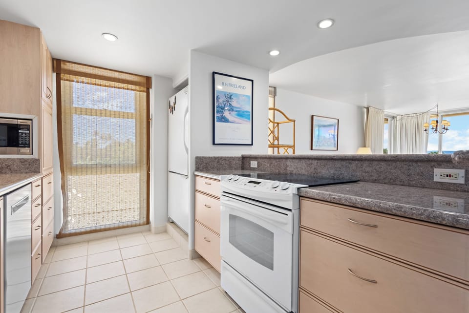 Prepare fresh meals in your bright, fully-equipped kitchen featuring modern appliances and lovely ocean breezes flowing through the patio door.