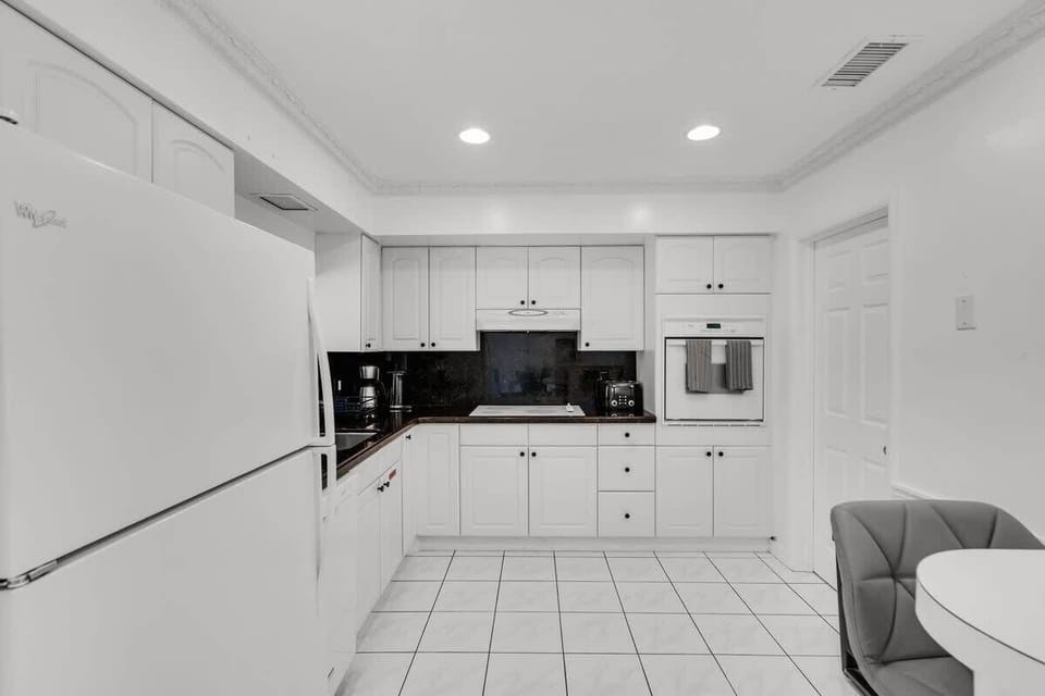 Bright, clean, and fully equipped for comfort 🍳 This South Florida vacation rental kitchen features modern appliances, white cabinetry, and a cozy dining nook—perfect for families, groups, or long-term stays. Book your sunny escape today!