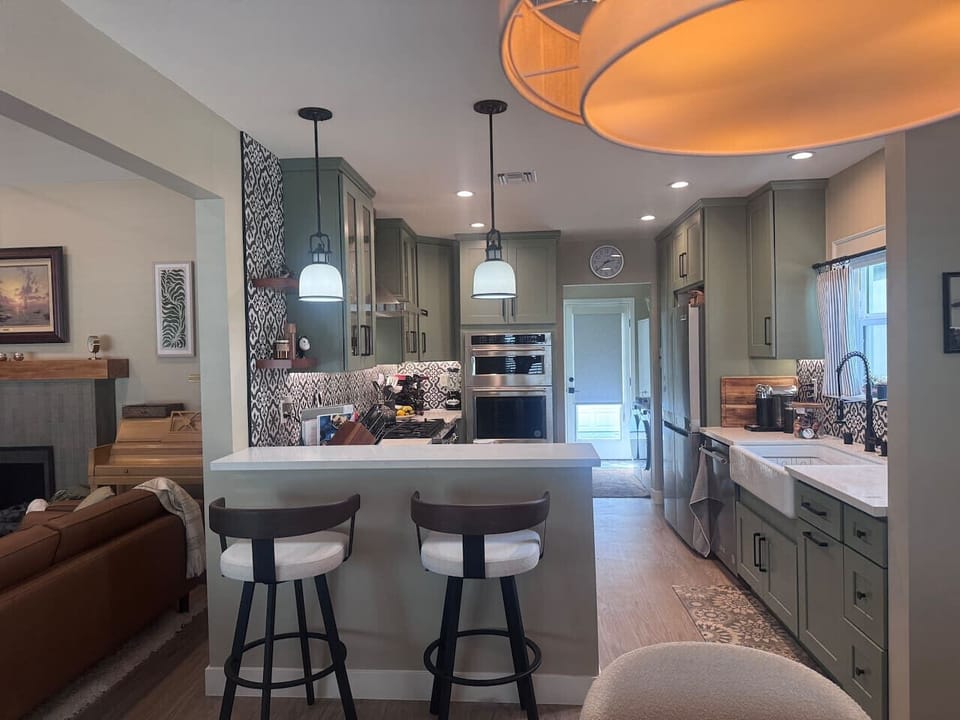 View of bar seats, kitchen, laundry room, and back door to yard.