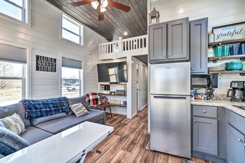 Charming and airy living room with vaulted ceilings, cozy sofa, and a large smart TV—your perfect spot to relax and feel right at home