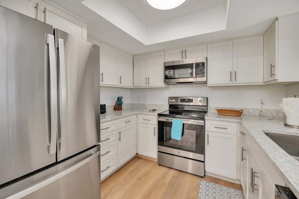 Kitchen with white cabinets, granite counters, and stainless appliances