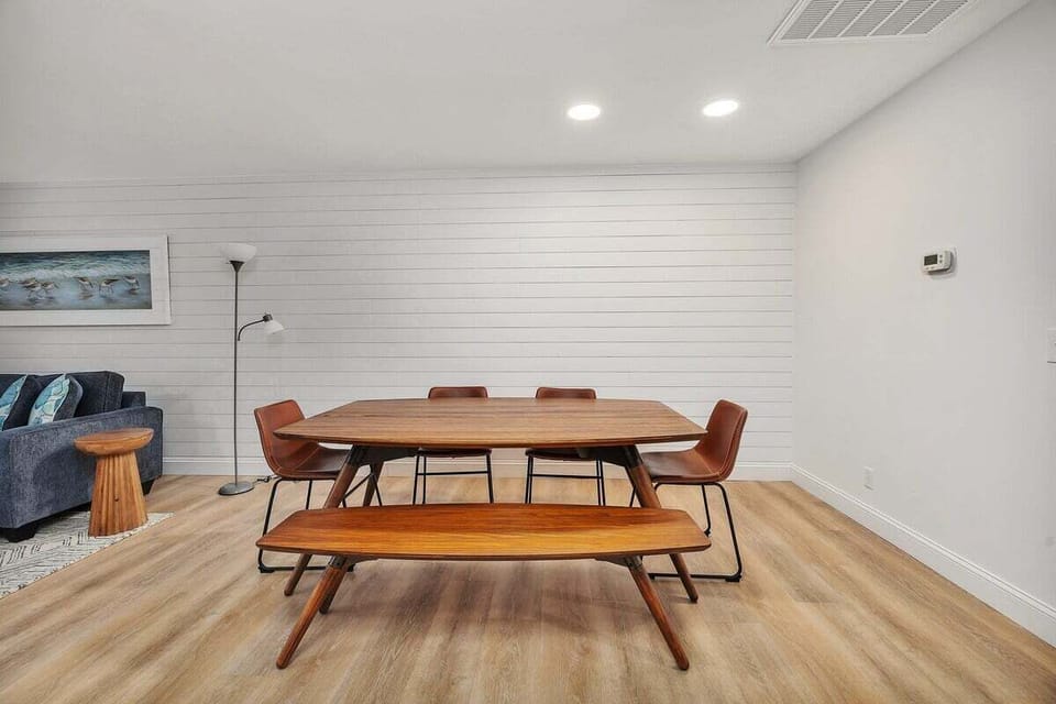 Dining area with wood table, bench, and shiplap wall
