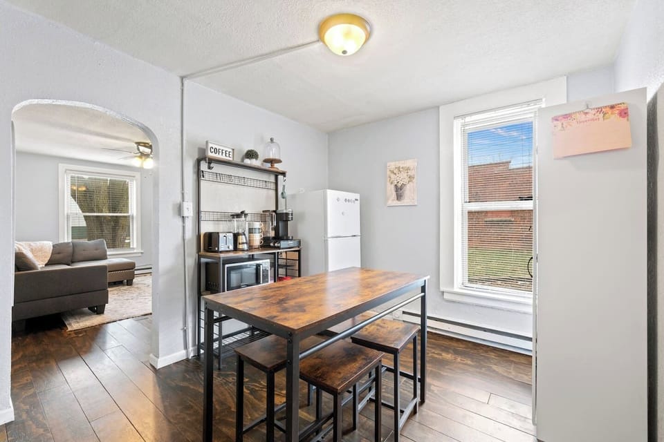 Fully equipped kitchen with all the necessary supplies, alongside a dining table for four and bar stools for casual seating.