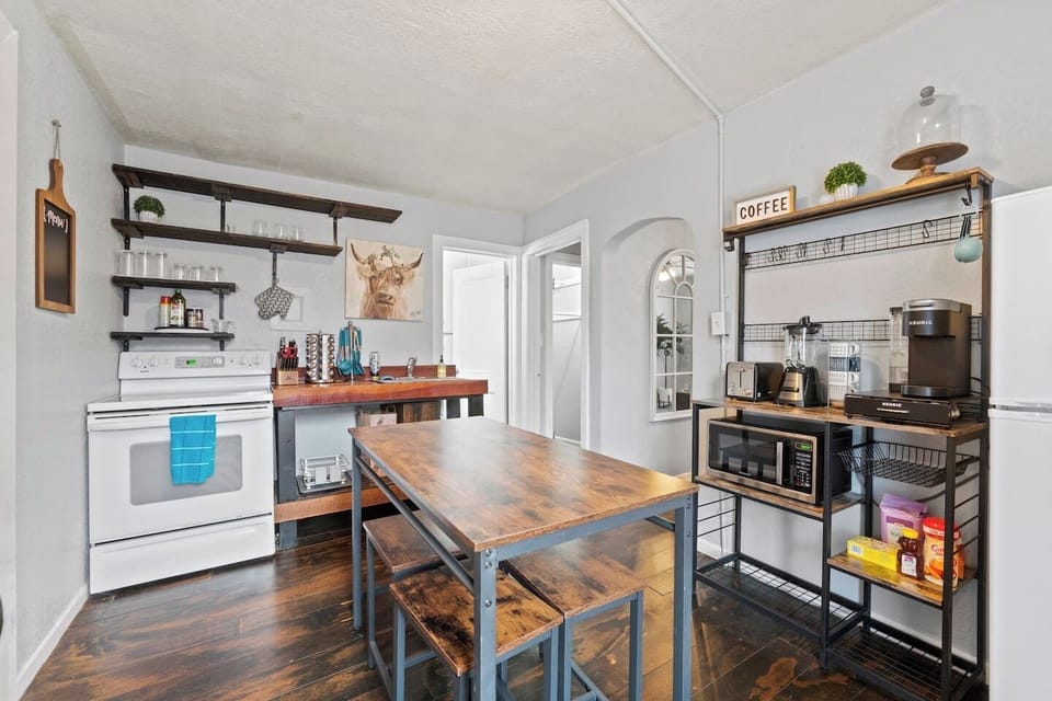 Fully equipped kitchen with all the essentials, complemented by a dining table for four and bar stools for casual seating.