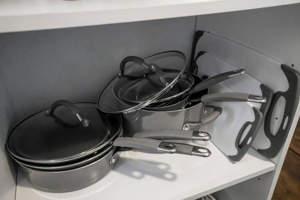 Close-up view of pots, pans, and cutting boards, offering all the kitchen essentials for meal preparation."