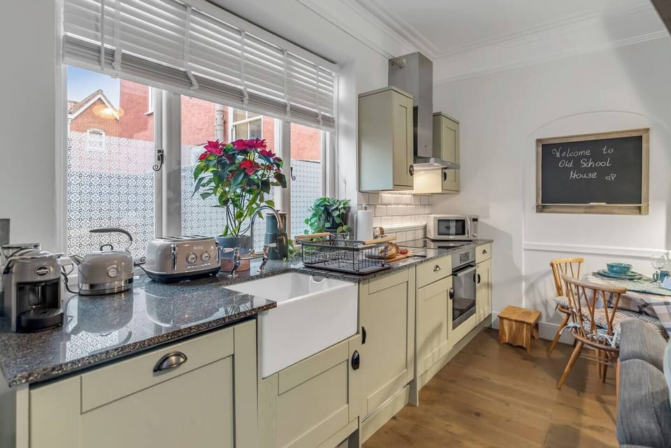 A modern kitchen equipped with all essentials, including an oven, hob, microwave, toaster, and coffee station. Enjoy a full set of tableware and cookware, a refrigerator, and a dishwasher for convenience. Perfect for preparing and enjoying meals during your stay.