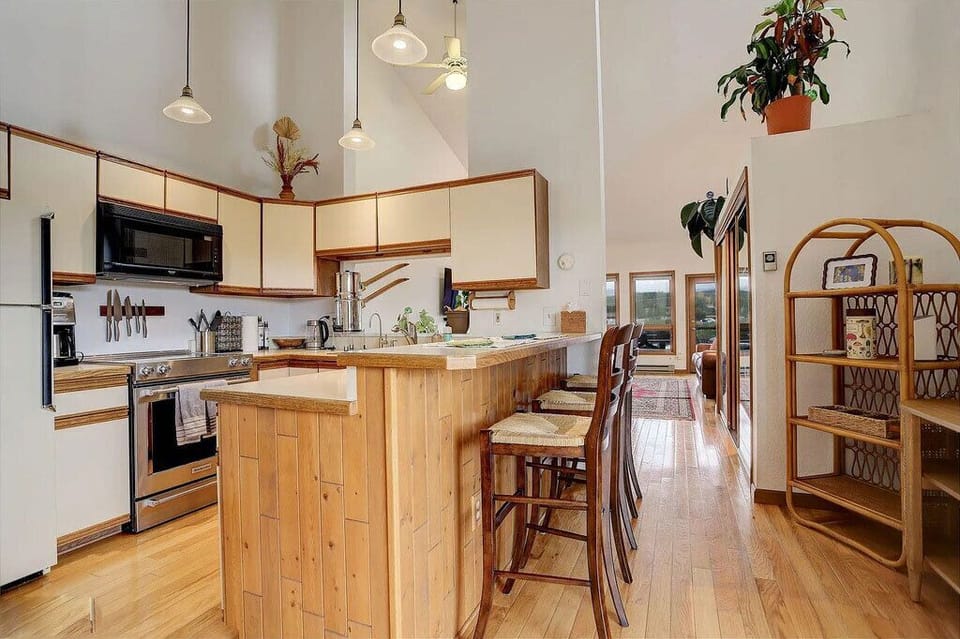 Your spacious kitchen features warm wood cabinets, granite counters, and a breakfast bar perfect for morning coffee or casual meals together.