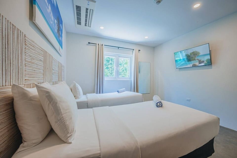 Bedroom 2 | Whether you`re a guest or seeking a moment of solitude, this inviting space promises relaxation and rejuvenation, making it the perfect home away from home. Two single beds, crisp white cotton bedding, TV and ensuite bathroom