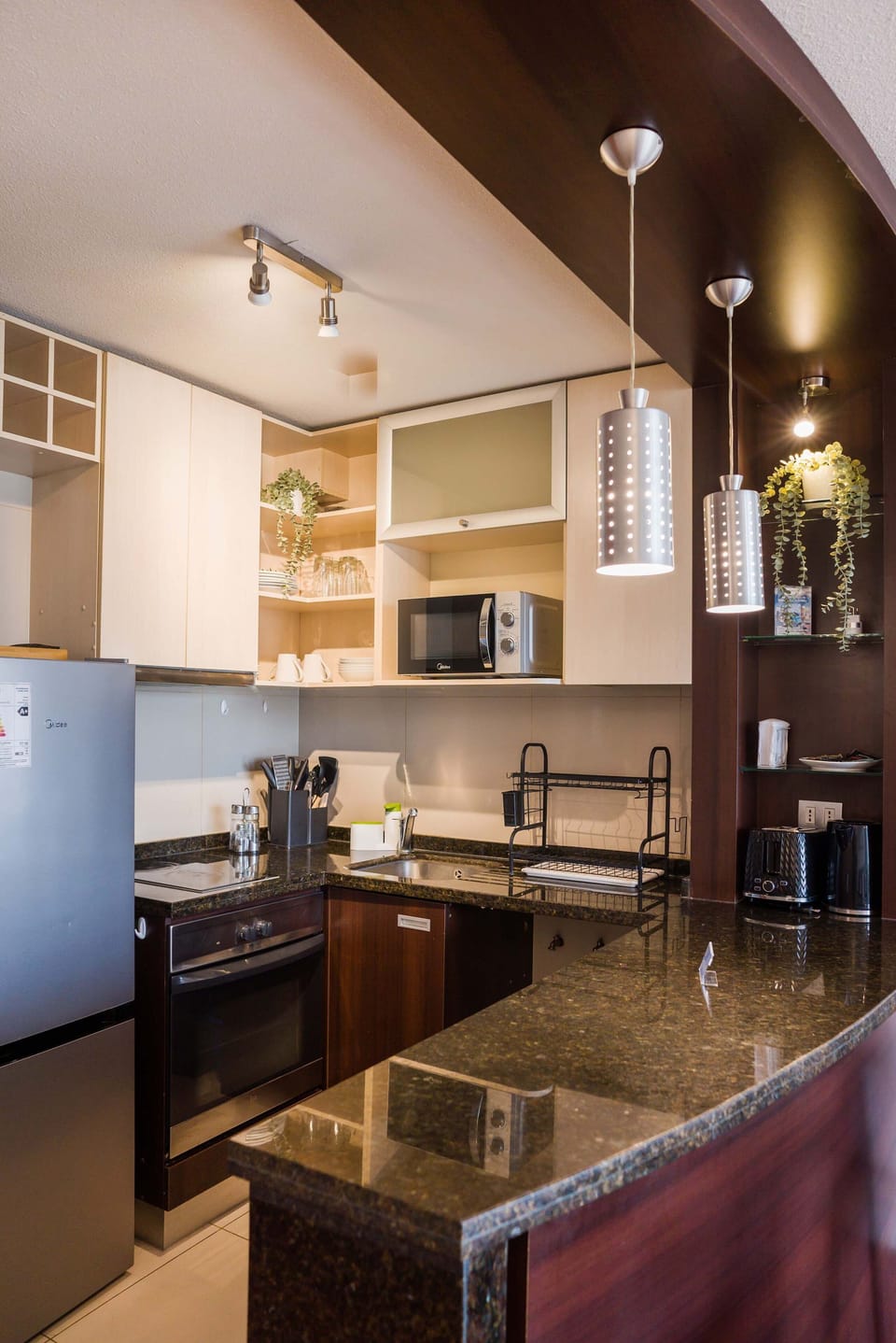 Sleek and modern kitchen with granite countertops and all essential appliances for a comfortable stay.