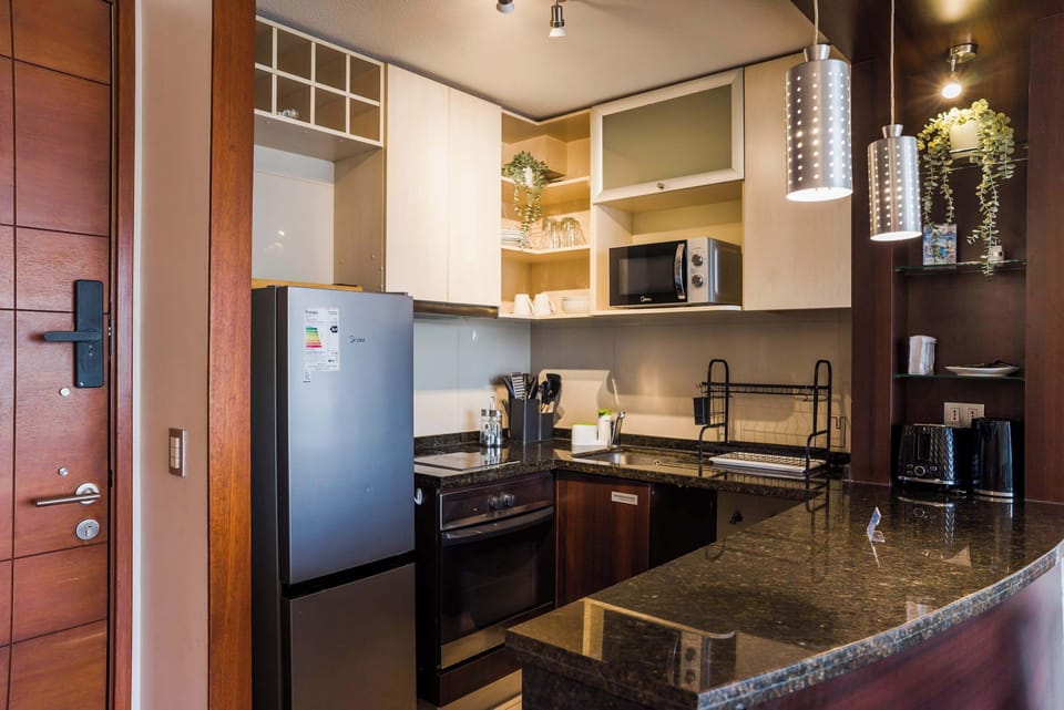 Modern kitchen with sleek appliances and stylish lighting, perfect for cooking and dining in comfort.