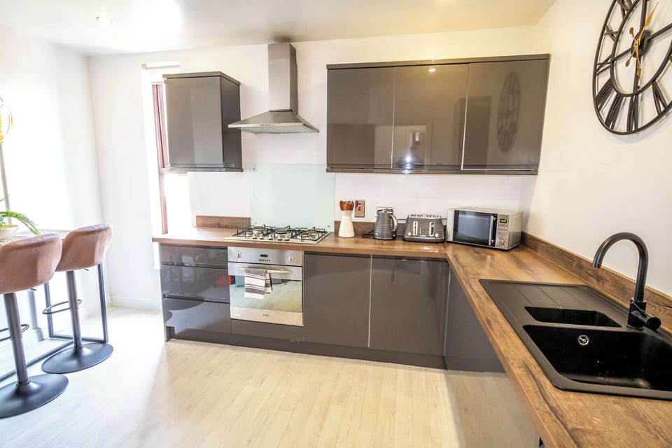 Modern kitchen with breakfast bar seating, perfect for morning coffee or a quick bite before exploring Didsbury