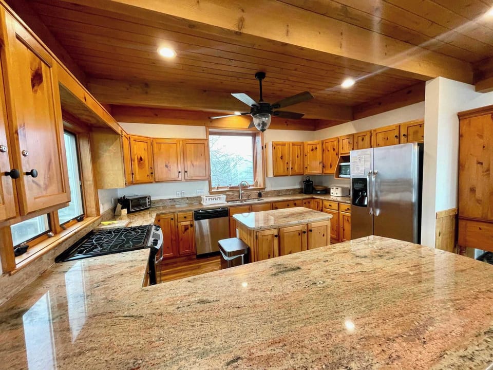 Embrace the art of cooking in our fully-outfitted kitchen featuring solid wood cabinetry and granite counters. A harmonious blend of aesthetics and practicality awaits your culinary adventures.