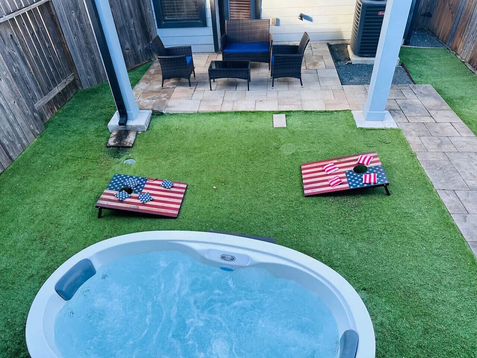 Private fenced backyard with hot tub, patio and corn hole