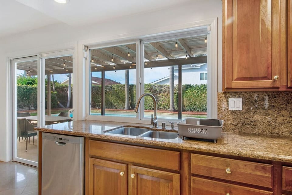 fully-equipped kitchen while overlooking the sparkling pool and lush backyard oasis.