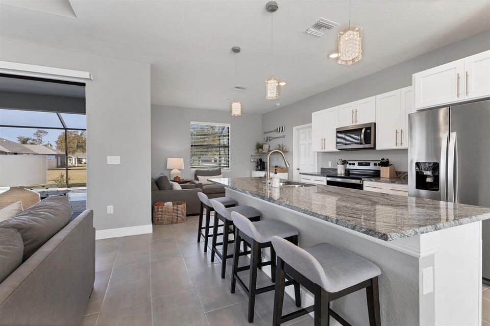 Fully equipped kitchen overlooking living room and dining area. Kitchen island seats 4