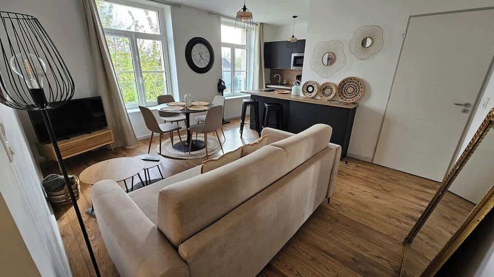 Salon avec canapé convertible, télévision, table à manger pour 4 personnes. 
Le salon est ouvert sur la cuisine.