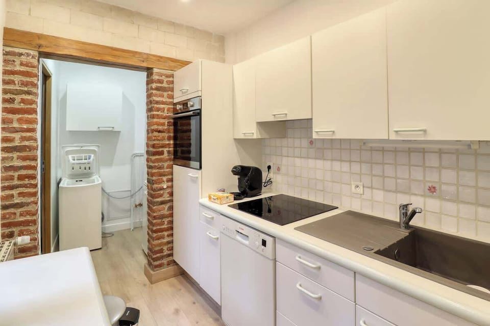 Cuisine équipée avec four, micro-ondes, machine à café, bouilloire, lave-vaisselle, réfrigérateur avec congélateur, plaques de cuisson et machine à laver.
Le lave-linge et le réfrigérateur se trouvent dans l'arrière cuisine (visible dans le fond).