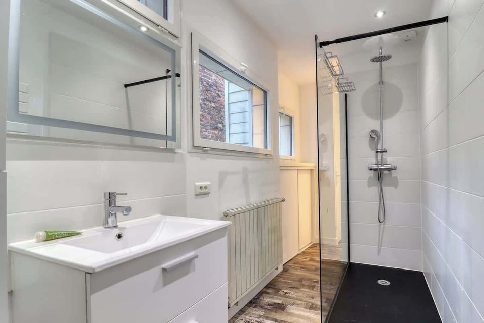 Salle de bain à l'étage avec douche à l'italienne, toilettes (dans le fond de la pièce) et sèche cheveux.