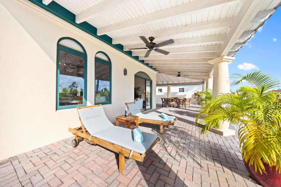Covered patio with comfortable lounge chairs, ideal for enjoying the outdoors.