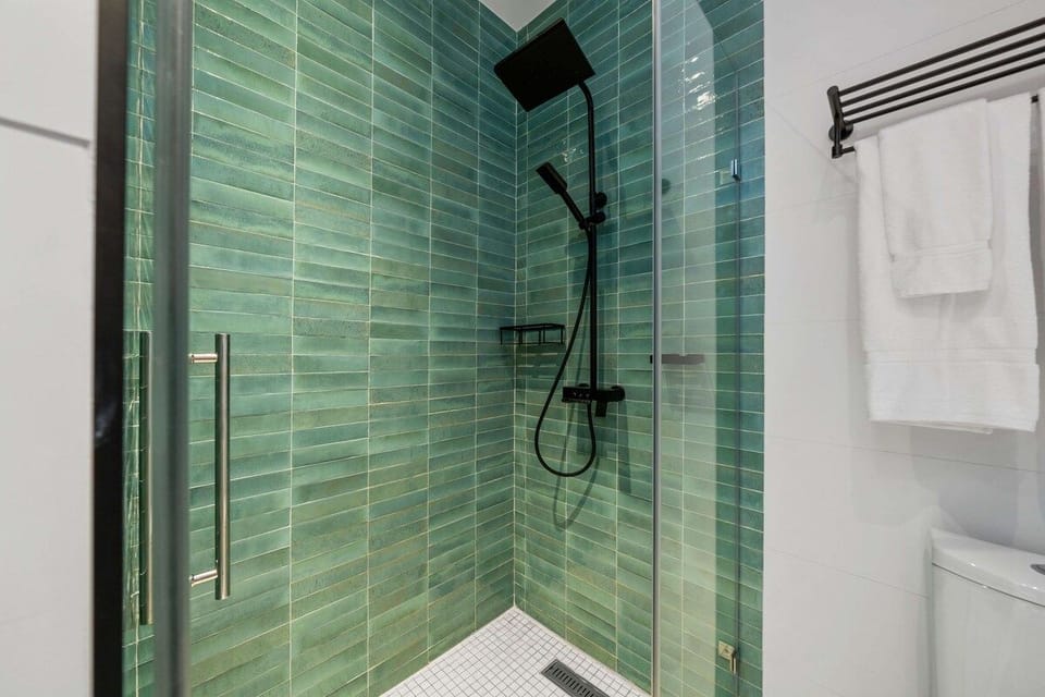 - Indulge in spa-like serenity with this striking green-tiled shower, adorned with sleek black fixtures that exude modern elegance
- Elegant and modern, designed for ultimate relaxation and rejuvenation
- Refreshing oasis to start or end your day
