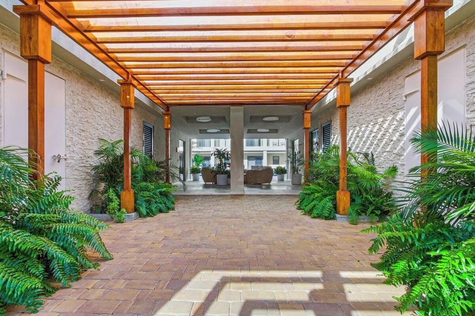 - Bright and airy corridor framed by greenery and a sleek wooden pergola inviting you to a serene space