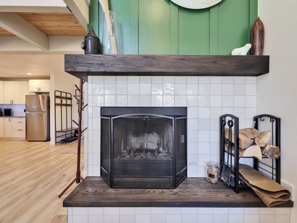 Bright and spacious living room, newly remodeled, featuring a cozy wood-burning fireplace