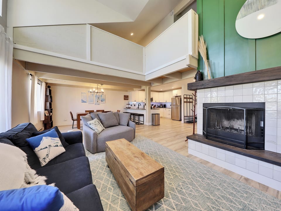 Bright and spacious living room, newly remodeled, featuring a cozy wood-burning fireplace