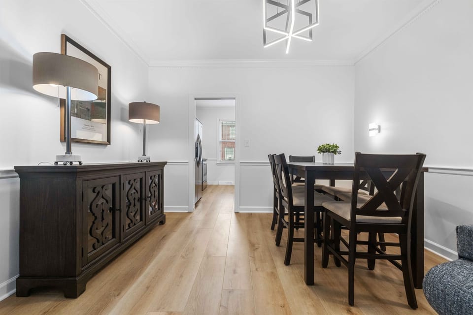 The dining area features a wooden table for six, with additional seating for 4 in the kitchen 