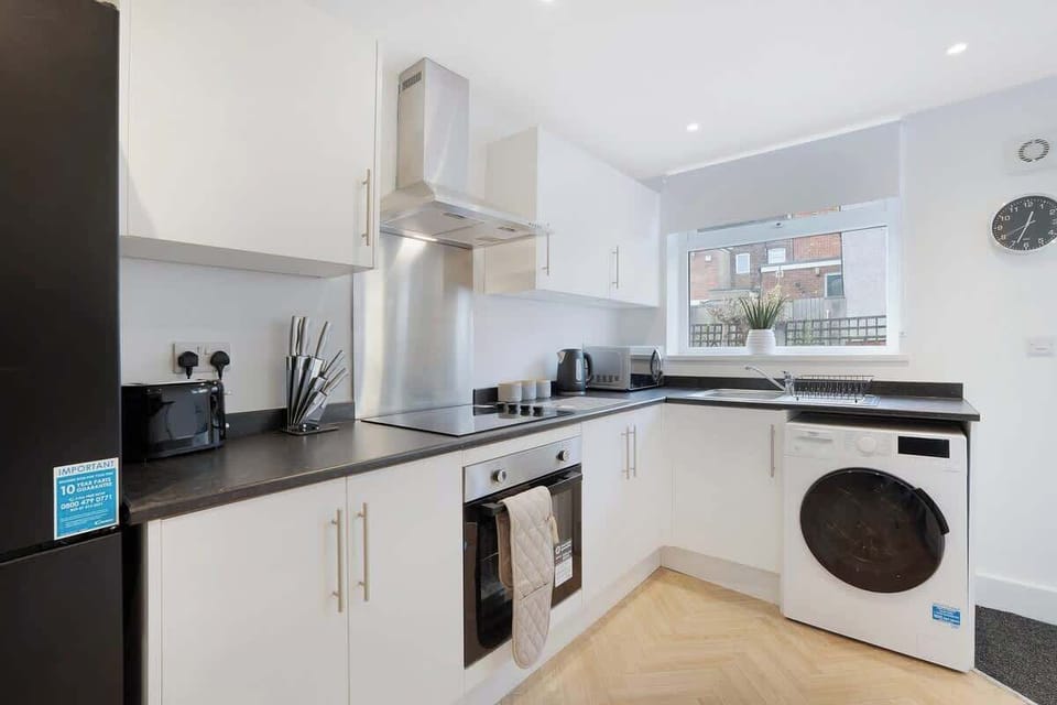 Kitchen oasis equipped with all essentials, including a washer & dryer, oven, fridge and full cookware set.