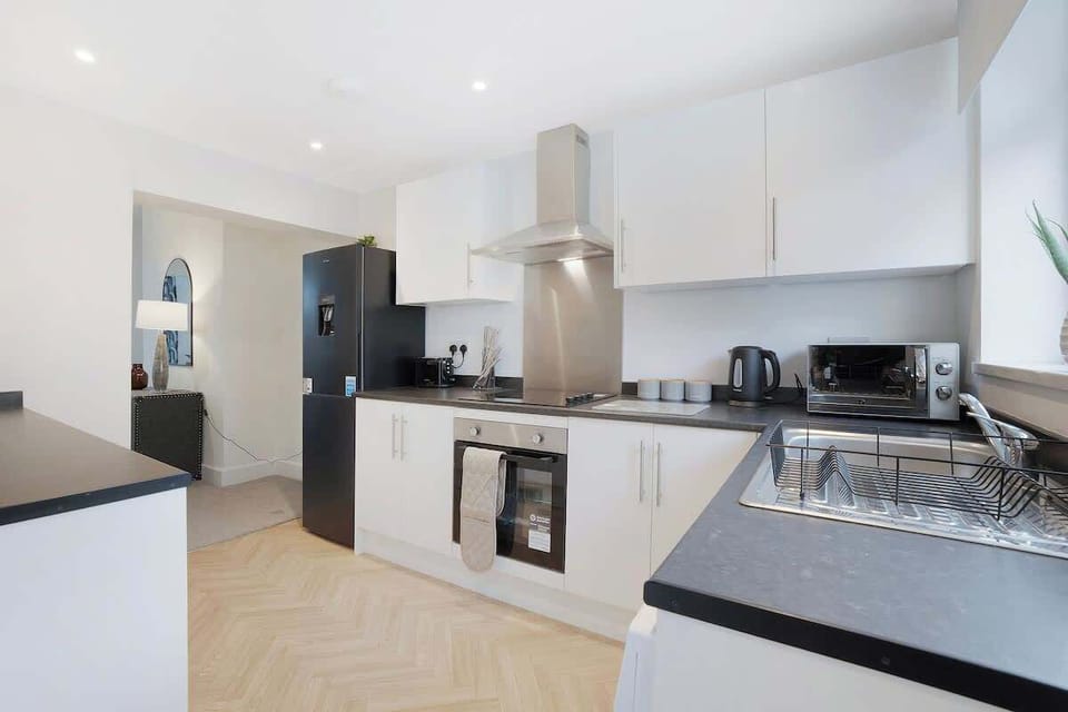Kitchen oasis equipped with all essentials, including a washer & dryer, oven, fridge and full cookware set.