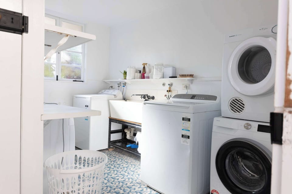Laundry with washing machine, dryer, tub and storage shelves